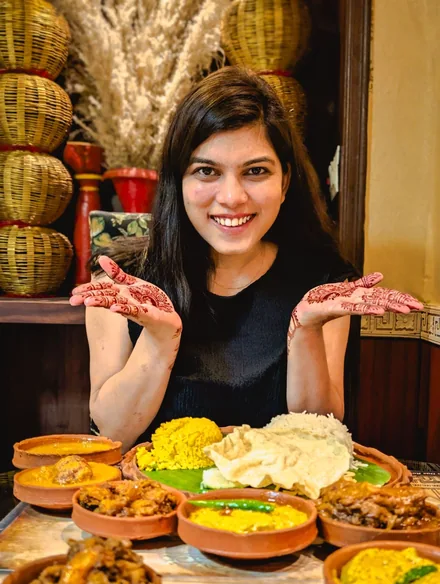 A woman enjoying a thali in a restaurant