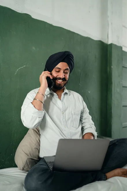 A man on a call beside his laptop